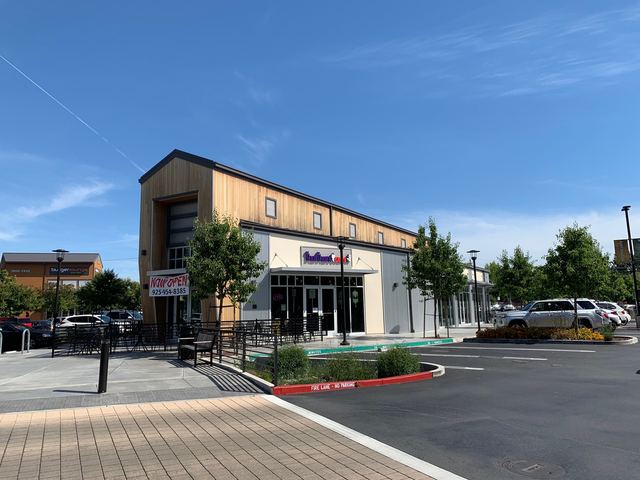 Restaurant building with wood siding and patio seating