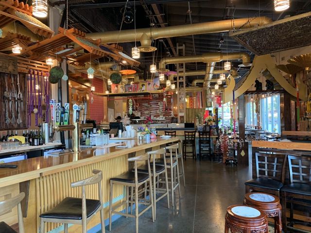 Bar stools along a wooden counter with the dining room beyond