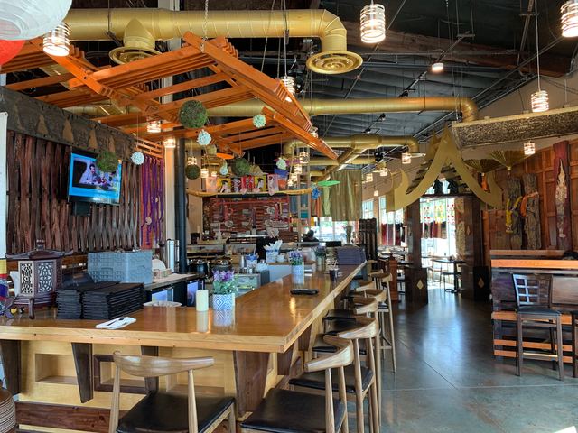 Long wooden bar with stools under carved wooden beams