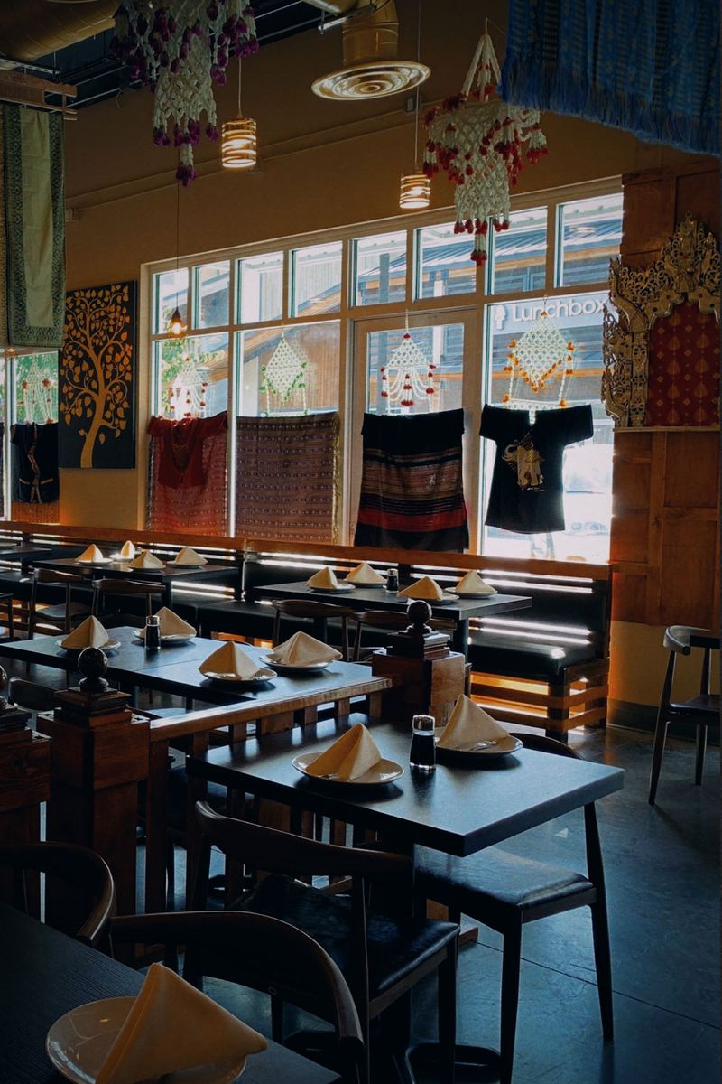Dining room with dark wooden tables and hanging textiles